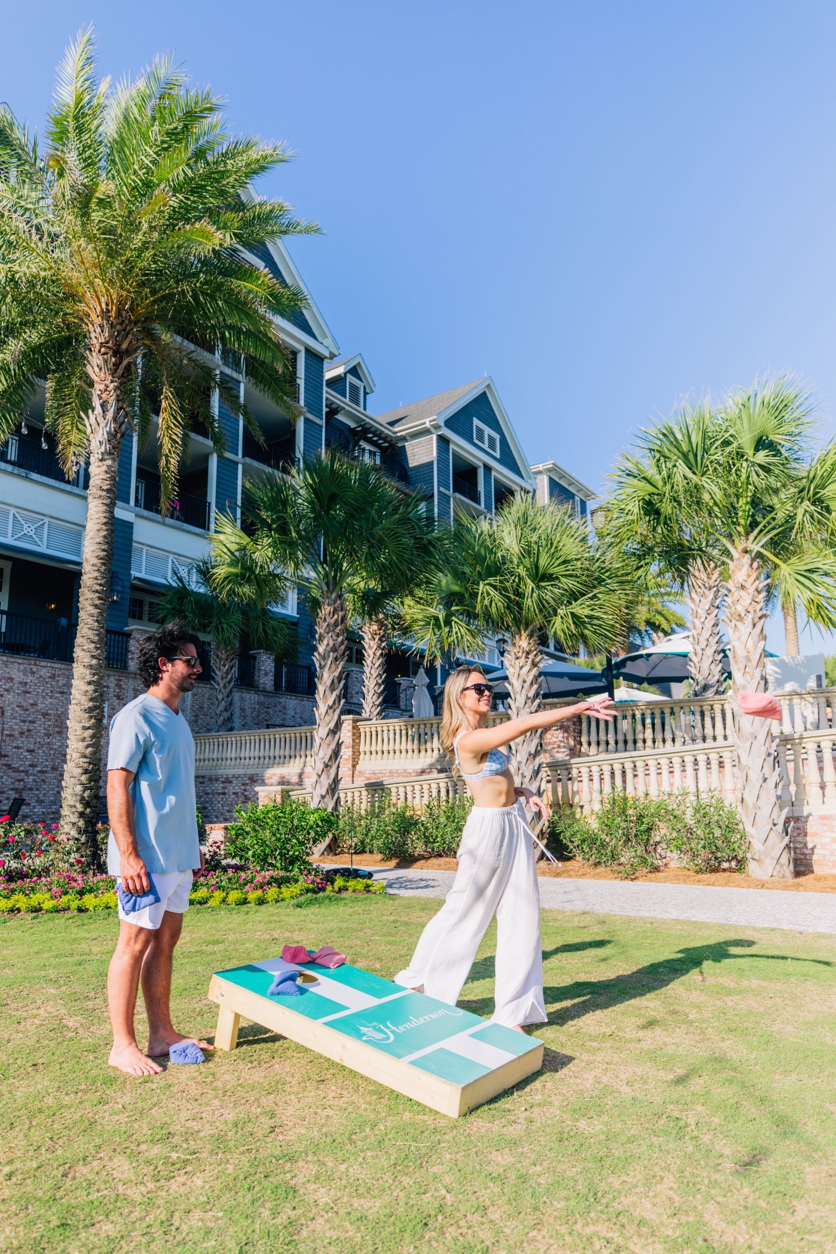 couple playing cornhole on resort lawn